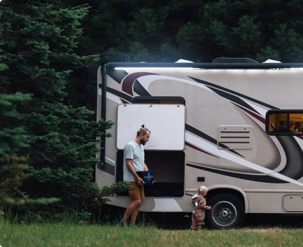 A father retrieves a portable power station from the vehicle's storage compartment