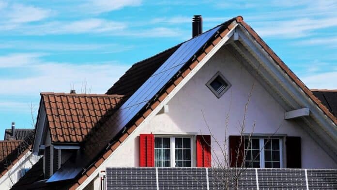 A house with solar panels installed on both the sloped roof and balcony