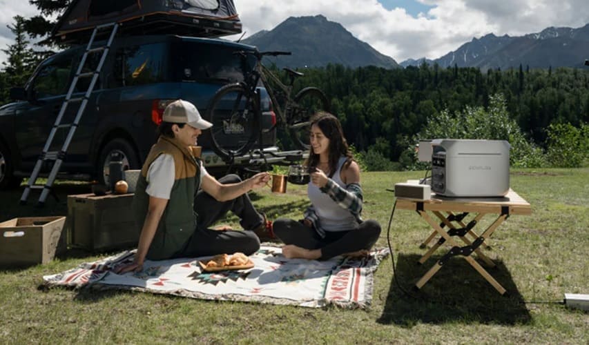 Couple enjoying a picnic in nature with a portable power station