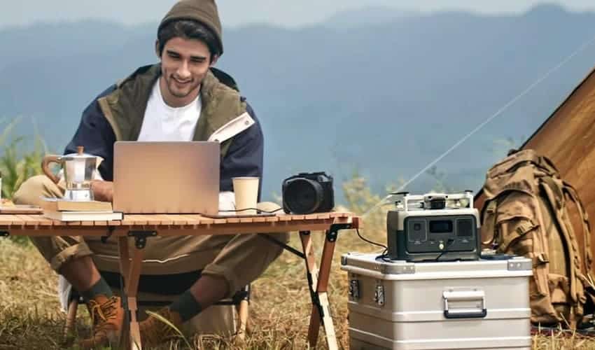 Man works on a laptop powered by EcoFlow river 2 portable power station