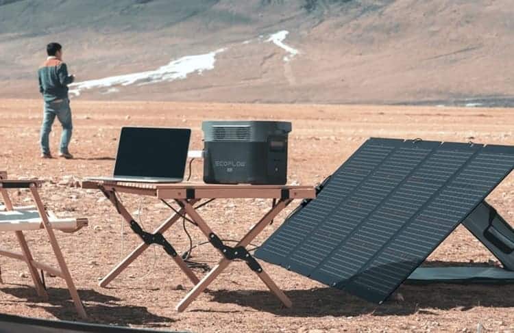 Outdoor camping setup with a solar panel powering a portable power station