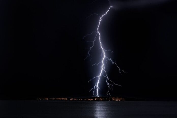 Powerful lightning bolt striking over a body of water