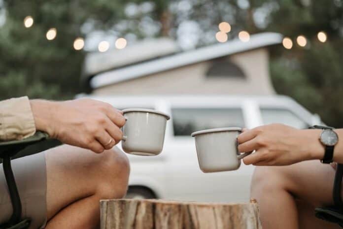 Two people toasting with camping mugs