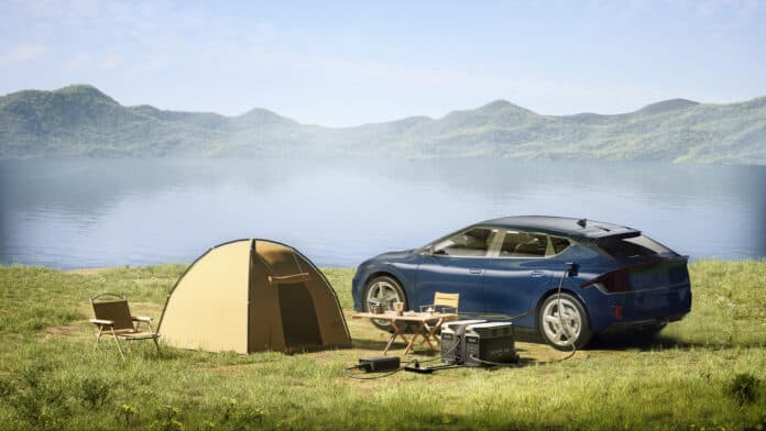 Landscape with tent, portable power stations, and electric vehicle