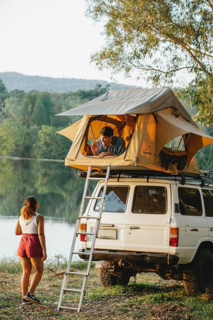 anonymous young couple chatting during camping on lake shore