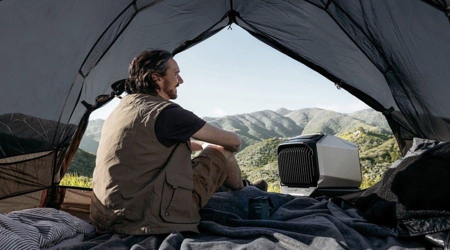 Man sitting in a camping tent with EcoFlow portable AC