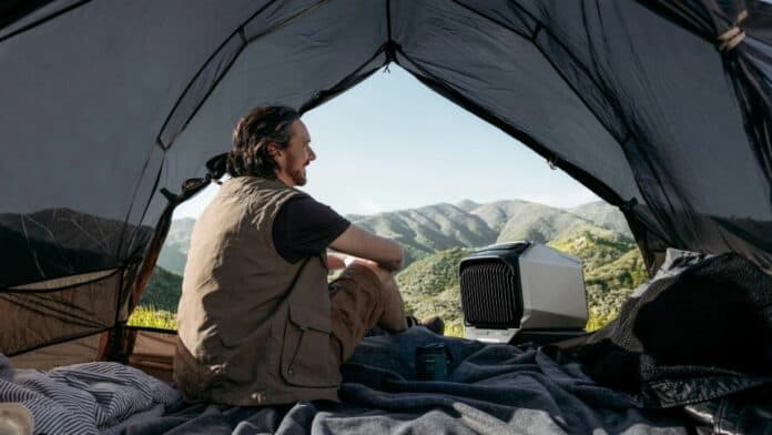 Man with EcoFlow portable AC sitting in tent